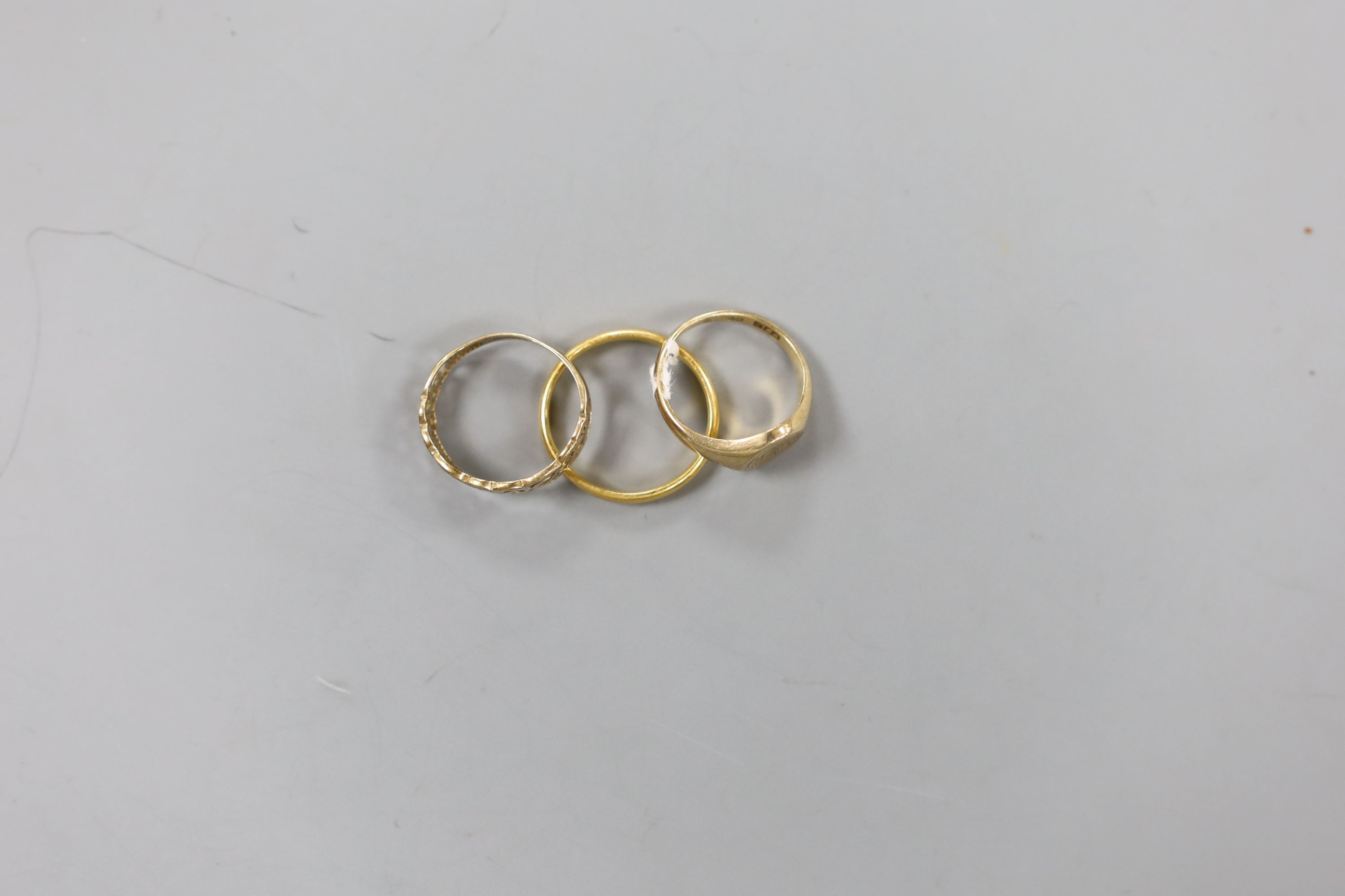 A modern 22ct gold wedding band, 3.3 grams and two 9ct gold rings including signet, 4.2 grams.